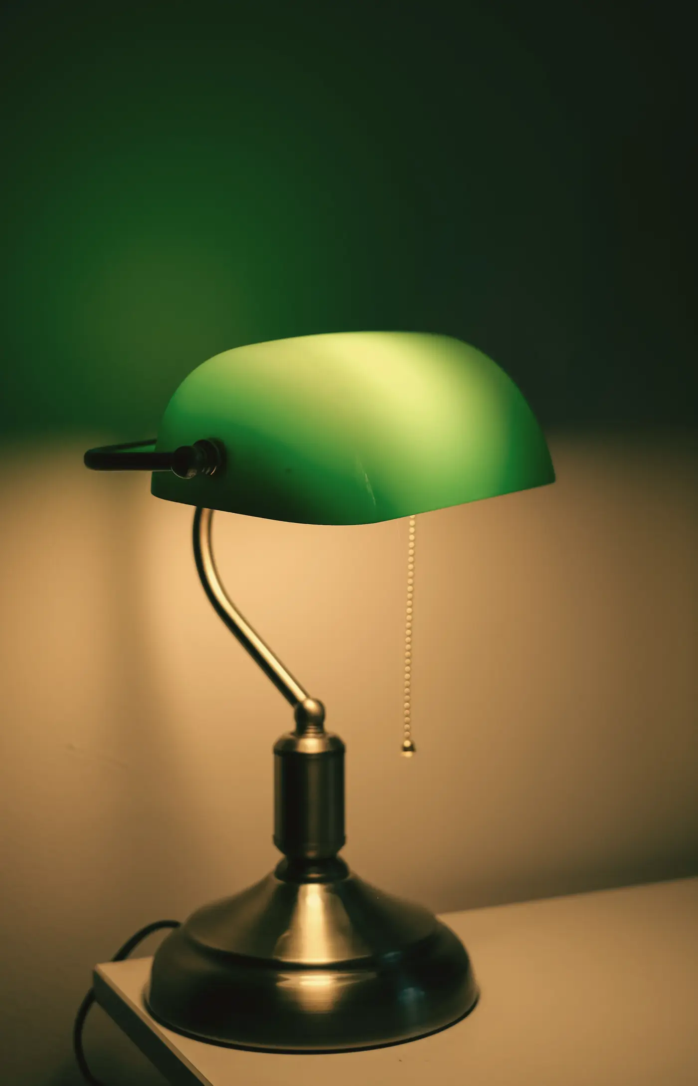 Lampe de bureau à abat-jour vert allumée